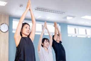 介護施設でのレクリエーション。入居者が指導者の下でストレッチ運動を行っている。